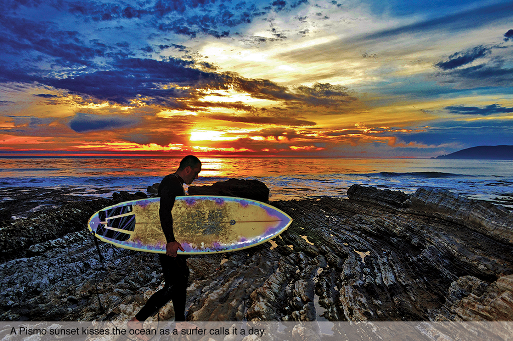 A Pismo sunset kisses the ocean as a surfer calls it a day.